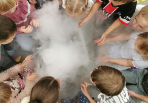Dzieci obserwują dym powstały w eksperymencie z suchym lodem