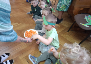 Dzieci częstują się plasterkami marchewki