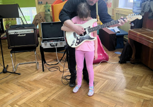 Dziewczynka uczy się grać na gitarze