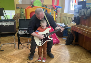 Chłopiec trzyma gitarę