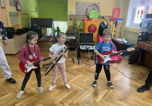 Trójka dzieci gra na gitarze