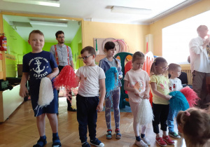 Dzieci stoją z pomponami w rękach
