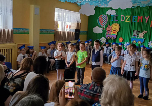 Grupa dzieci recytuje wiersze o pożegnaniu przedszkola i starszaków