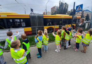Dzieci machają do pasażerów przejeżdżającego autobusu