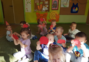 Dzieci w grupie pokazują emblemat jabłka