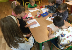 Dzieci rysują przy stole w towarzystwie kolegów ze szkoły