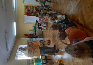 Dzieci patrzą na planszę z pszczołami siedzącymi na plastrze miodu