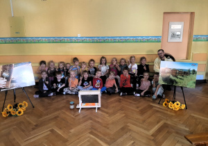 Dzieci pozują do zdjęcia z panem pszczelarzem