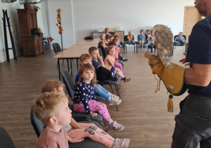 Dzieci obserwują pana trzymającego sowę