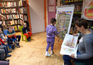 Dziewczynka przyczepia na mapie Łodzi pinezkę zaznaczając atrakcyjne miejsce