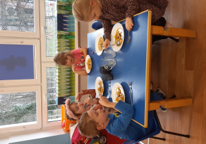 Dzieci jedzą zupę dyniową z grzankami