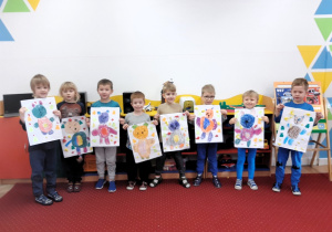 Dzieci pozują do zdjęcia z narysowanymi przez siebie misiami
