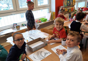Grupa dzieci rysuje przy stole