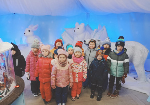 Dzieci pozują do zdjęcia na tle zimowej scenerii