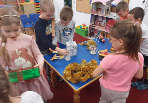 Dzieci uczestniczą w zabawie tematycznej "Na jarmarku bożonarodzeniowym"