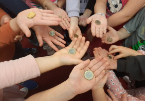 Dzieci pokazują monety euro