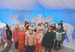 Dzieci pozują do zdjęcia z figurą niedźwiedzia polarnego