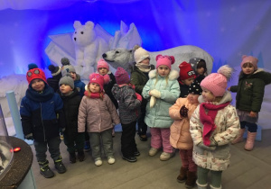 Dzieci pozują do zdjęcia z figurą niedźwiedzia polarnego