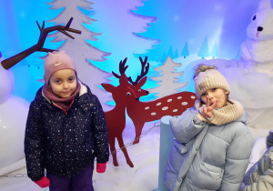 Dwie dziewczynki pozują przy świątecznej dekoracji