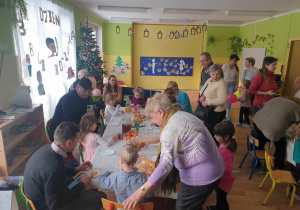 Dzieci i ich dziadkowie ucztują przy stołach
