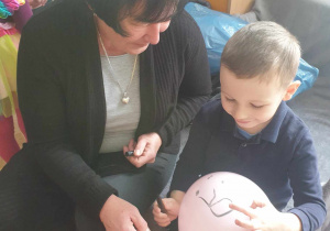 Babcia rysuje na balonie z wnuczkiem