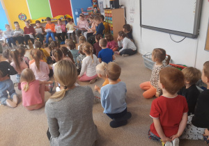 Dzieci słuchają bajki czytanej przez uczniów