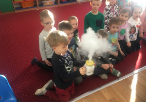 Dzieci obserwują, jak suchy lód wydobywa się z pojemnika