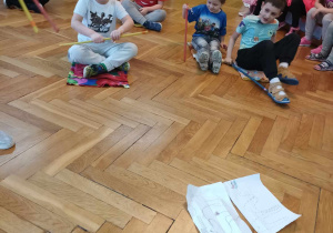 Grupa chłopców siedzi na podłodze.
