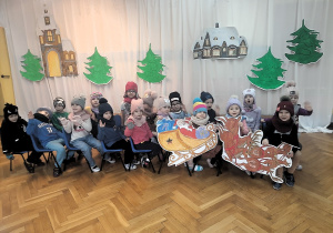 Dzieci siedzą w zaprzęgu św. Mikołaja i jadą do Laponii