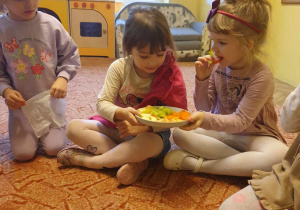 Dziewczynki częstują się owocami i warzywami