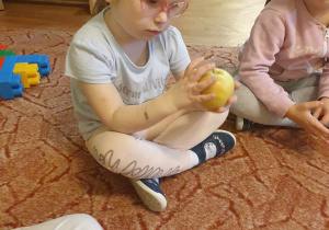 Dziewczynka sprawdza fakturę jabłka
