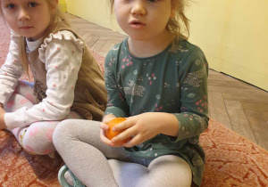 Dziewczynka określa wygląd mandarynki