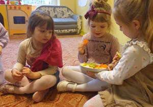 Dziewczynki jedzą owoce i warzywa