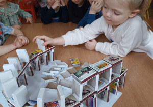 Dziewczynka buduje Koloseum z pudełek po zapałkach