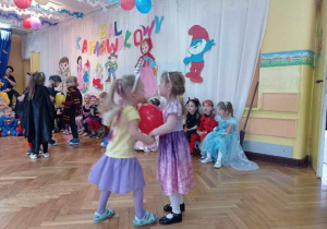 Dwie dziewczynki trzymają balon brzuchami