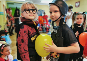 Chłopcy trzymają ściskają balon brzuchami