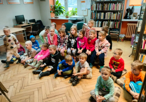 Dzieci słuchają opowiadania pani bibliotekarki