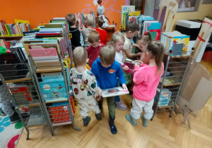 Dzieci oglądają książeczki w bibliotece