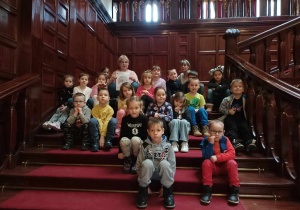 Grupa dzieci siedzi na schodach