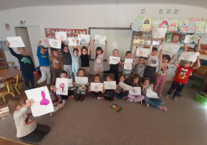 Dzieci prezentują narysowane przez siebie dinozaury