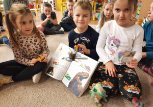 Dzieci trzymają przedmioty związane z dinozaurami