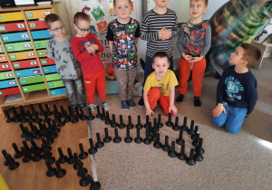 Chłopcy ułożyli kontur dinozaura z klocków