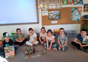 Dzieci prezentują figurki dinozaurów