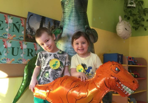 Dzieci pozują z dinozaurem