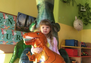 Dziewczynka pozuje z dinozaurem