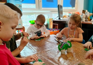 Dzieci wykonują prace plastyczne o dinozaurach