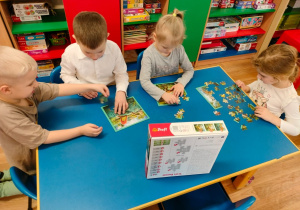 Dzieci układają puzzle o dinozaurach