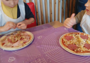 Chłopiec nakłada składniki na pizzę.