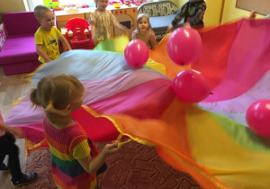Dzieci podczas zabawy chustą animacyjną i balonami