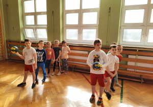 Dzieci ćwiczą na sali gimnastycznej.